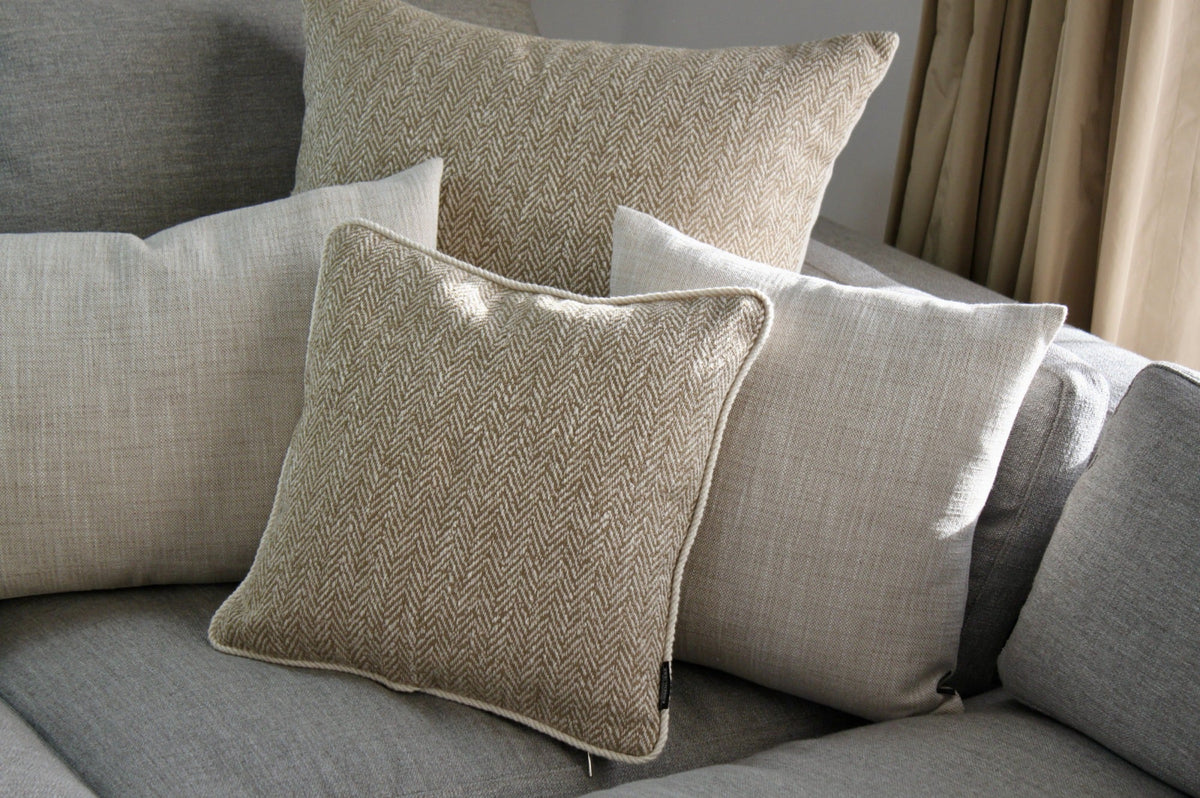 Sofakissen Fischgrat Olive groß LIPARIC 60x60 auf grauem Sofa | Manufaktur Kissenliebe